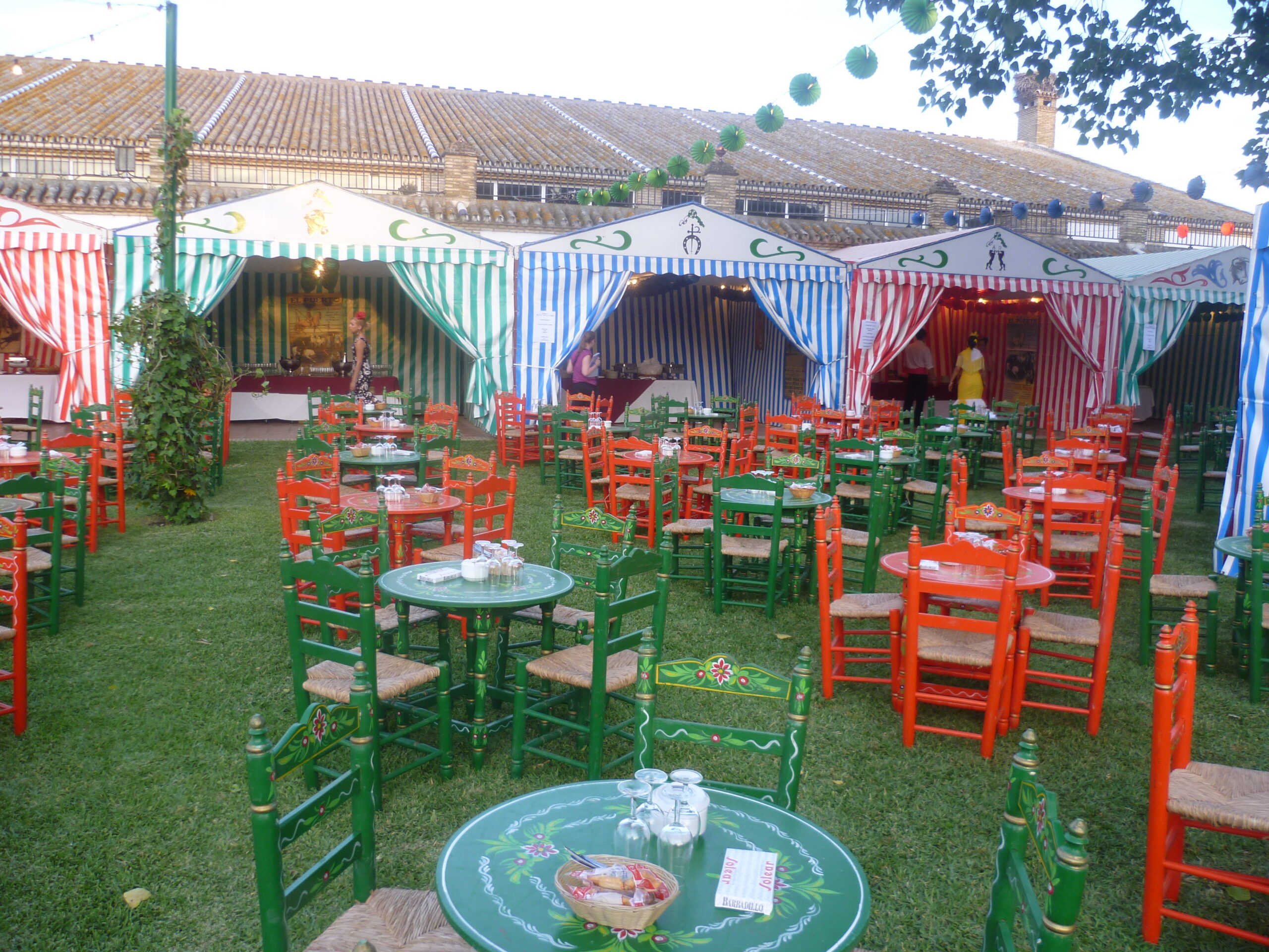 Ambiente festivo feria con sillas rojas y farolillos